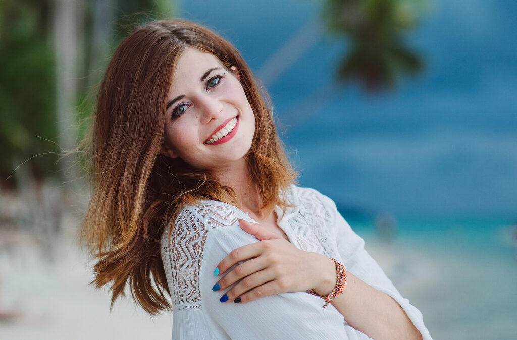 Sara, primehammer new technical recruiter, posing for a photo on the beach in a white dress.