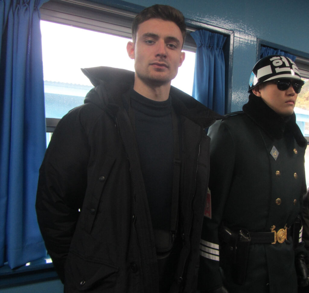 A photo of Daniel, a tall white man posing next to a South Korean official in Seoul.